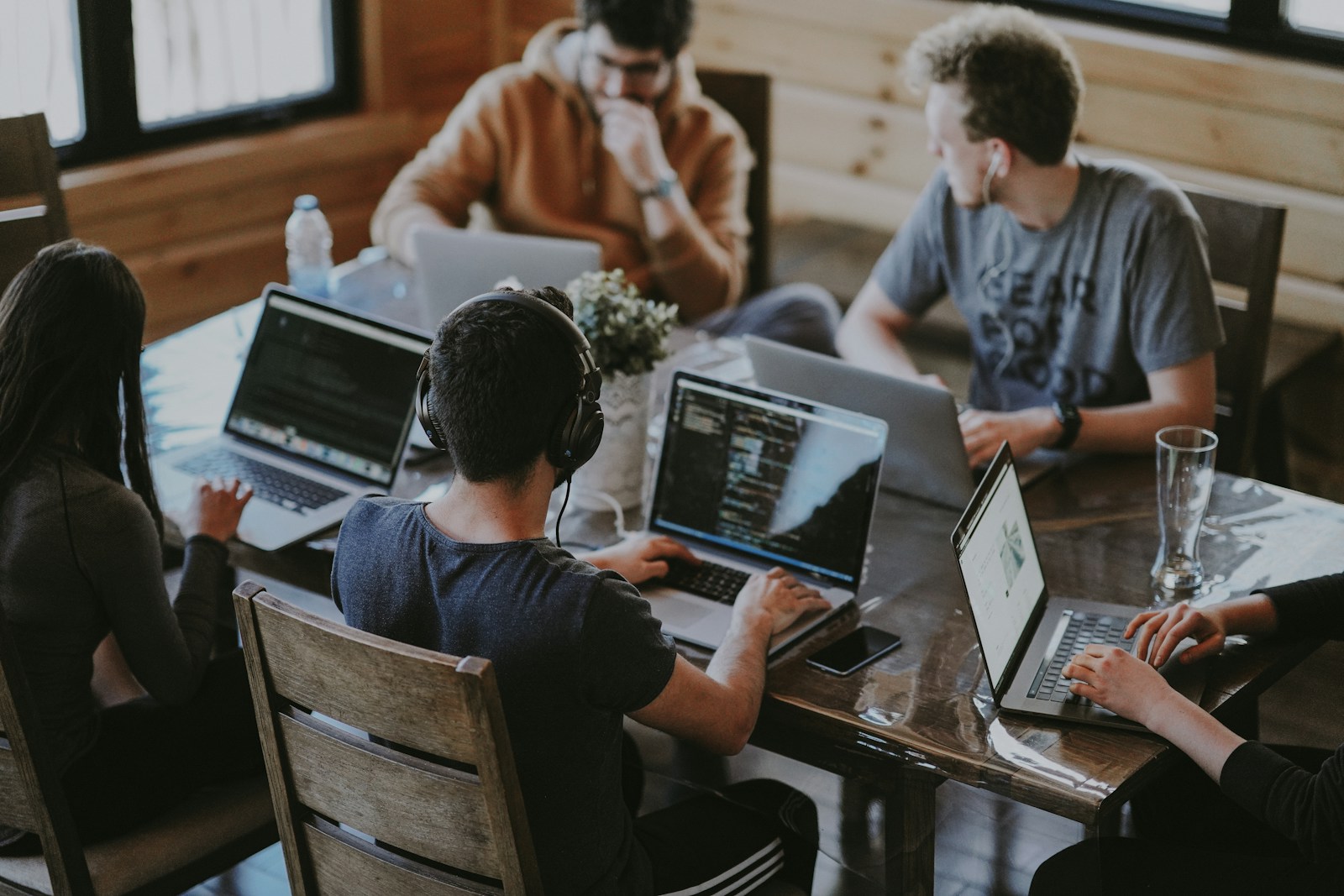 Colleagues discussing a project around a laptop in a bright shared workspace